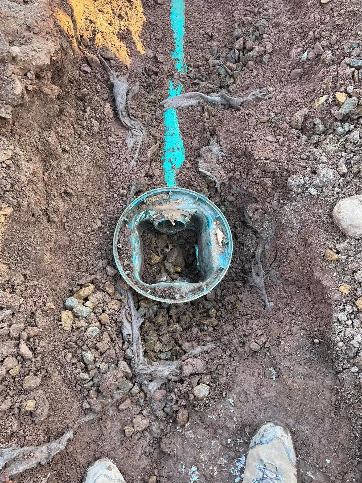 A septic distribution box exposed in an open trench during a Summit Septic repair